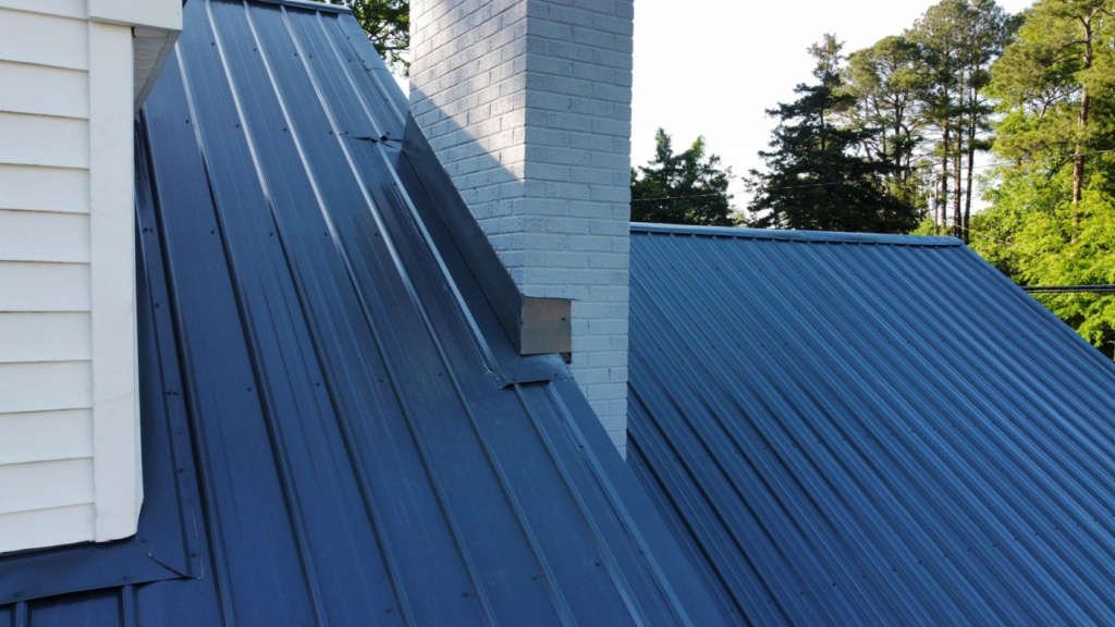 A close-up shot of a metal roof with a chimney.